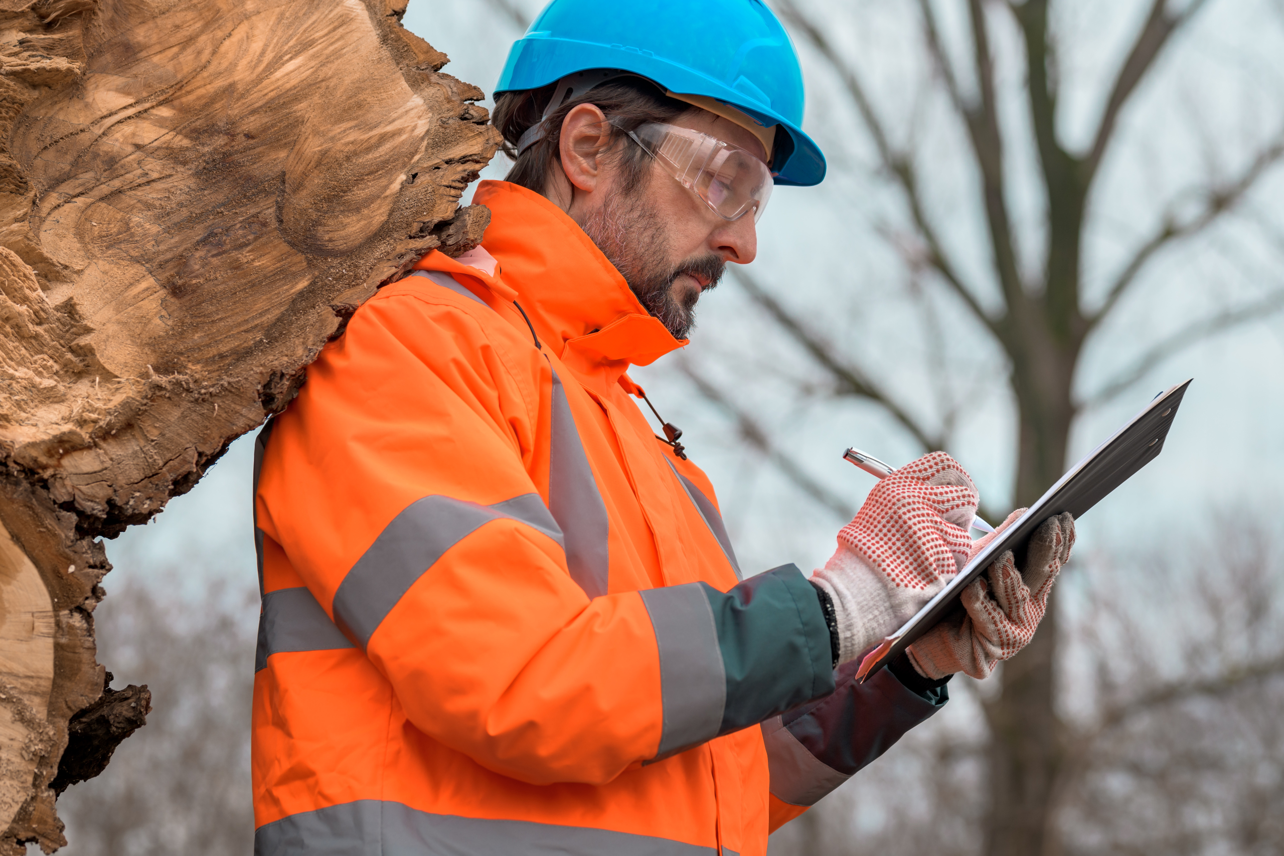 Forestry technician writing notes on clipboard notepad paper in
